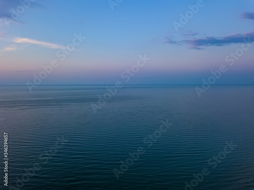 Aerial panoramic view of sunrise over sea. Nothing but sky, clouds and water. Beautiful serene scene