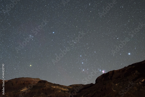 Gwiazdozbiór Oriona wschodzący zza góry na Teneryfie. Wiać mgławicę M42, zarys mgławicy koński łeb, pas oriona, oraz gwiazdę Betelgeza