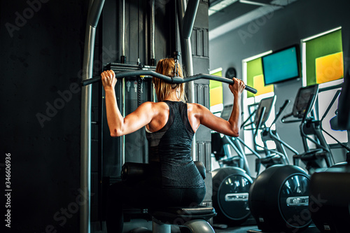 Kobieta trenująca na siłowni, mięśnie pleców. 