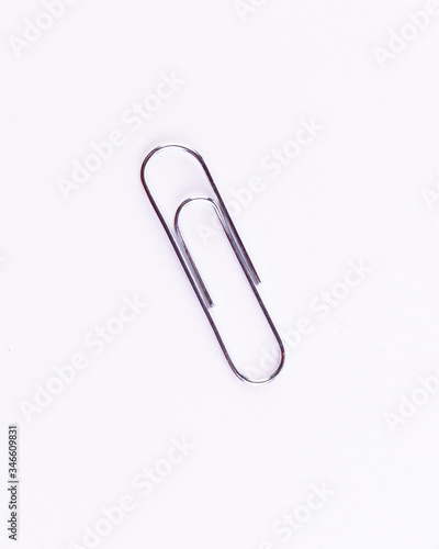 Silver office clip on a white isolated background.