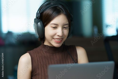 online training concept : Woman in headphones speaking looking at computer, student or teacher talking by video conference call.