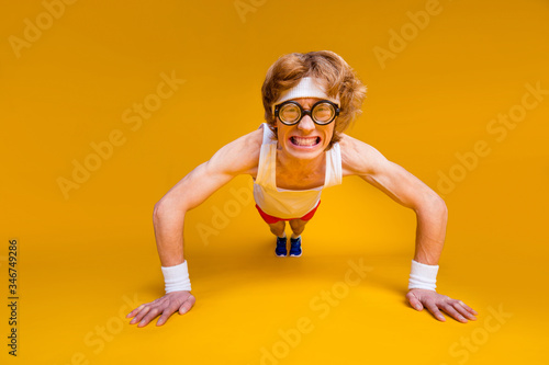 Portrait of his he nice funky motivated mad desperate foxy guy doing work out body building goal squatting endurance isolated over bright vivid shine vibrant yellow color background
