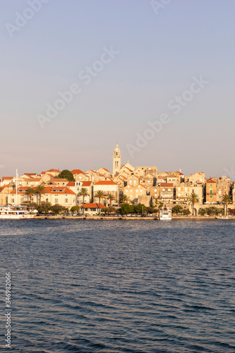 Korcula island with the old city walls, view from the sea on a sunny day during sunset. Clear adriactic sea, the mediterranean coast of Croatia, Europe. Seascape creating an idyllic scenery