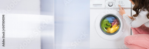 Woman Pressing Button Of Washing Machine