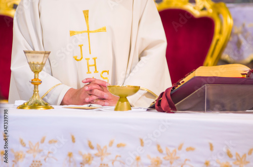 altar with missal and host which becomes the body of Christ and chalice to receive the wine, the blood of Christ