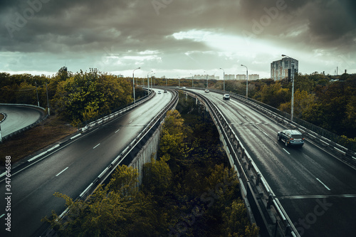 Urban bridge roads with traffic in gloomy rainy weather, dark toned.