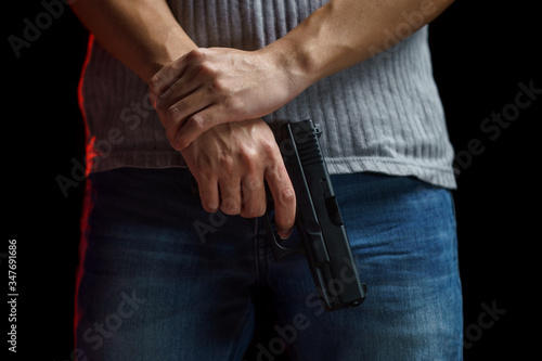 Man holding a gun on black background.