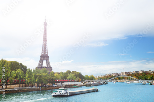 View over Seine river on Eifel tower with boats passing and Passerelle Debilly during summer, Paris France