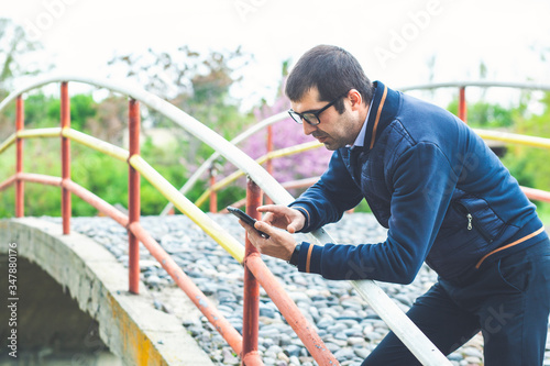 Young businessman sending a text message by mobile phone