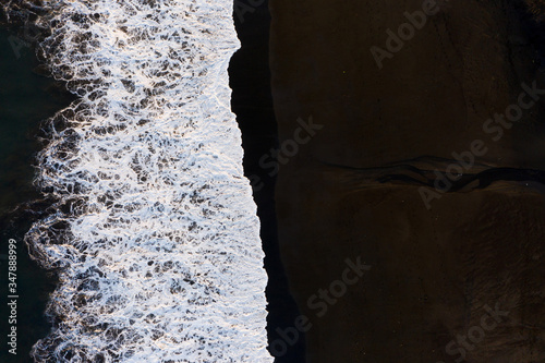 The black sand beach in Bali. Sea aerial view and top view.