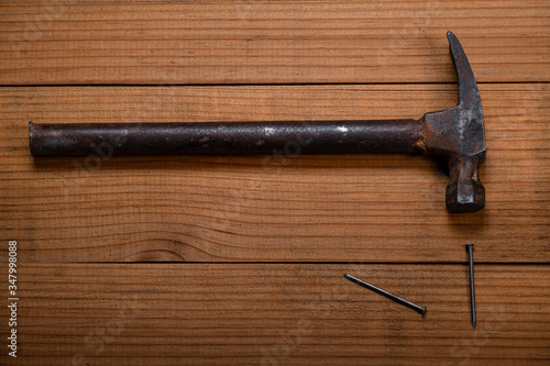 Martillo con clavos sobre una mesa de madera.