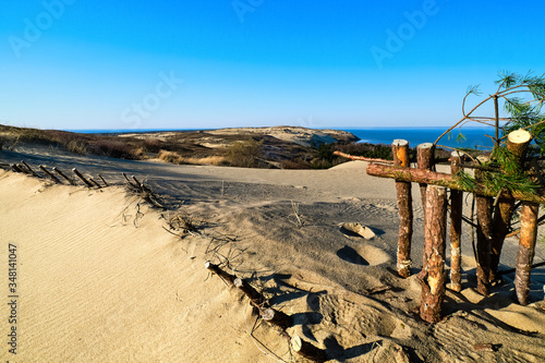View of diagonal nordic dune rib and protective fences of wood, pine branches, hills and Baltic sea at Curonian spit, Nida, Klaipeda, Lithuania.