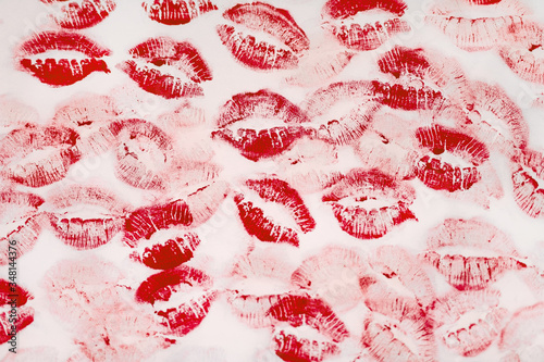 A lot of kissing marks made with the red lipstick on the white paper background - Image. Paper with lipstick kisses. Abstract passion love background. Imprints of female lips. 