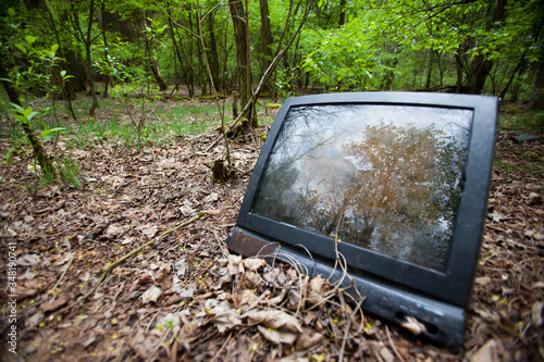 Stary telewizor wyrzucony w lesie.