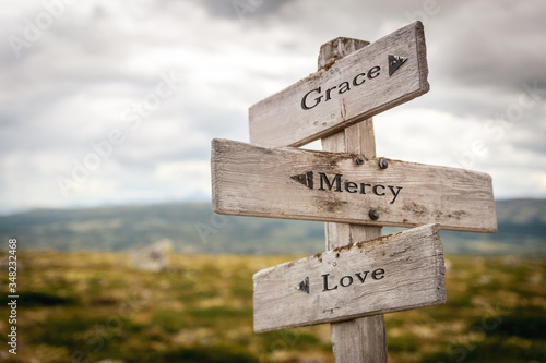 grace mercy love text engraved on old wooden signpost outdoors in nature. Quotes, words and illustration concept