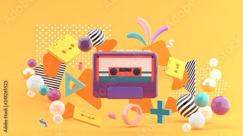 The tape player is surrounded by colorful tape and balls on an orange background.-3d rendering..