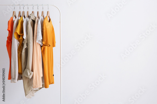 fashion clothes on a stand in a light background indoors. place for text 