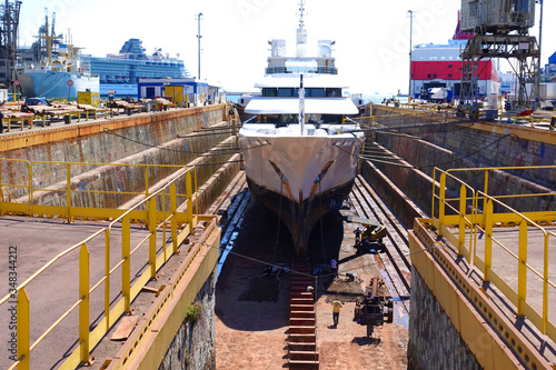 Photo of ship repairs of yacht in hull in shipyard floating dry dock