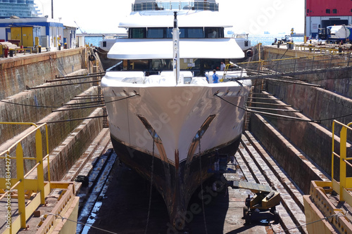 Photo of ship repairs of yacht in hull in shipyard floating dry dock