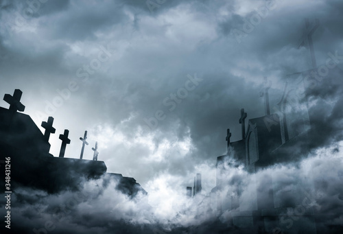 Cemetery or graveyard in the night with dark sky and white clouds. Haunted cemetery. Spooky and scary burial ground. Horror scene of graveyard. Funeral concept. Sadness, lament and death background.