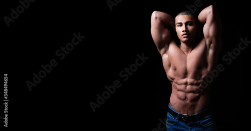 Portrait eines attraktiven, muskulösen und hübschen Mannes oberkörperfrei vor schwarzem Hintergrund 