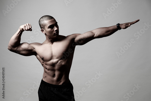 Attraktiver muskulöser Mann posiert vor grauem Hintergrund