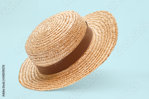 Boater straw hat flying isolated in studio. Concept of fashion clothing accessories and beach holidays