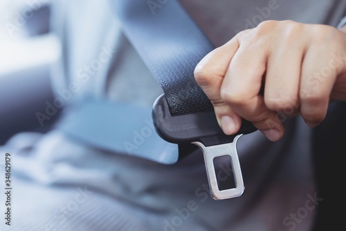 Close Up of people woman hand fastening seat safety belt in car for safety before driving on the road. concept transport travel. soft focus.