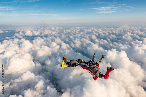 Group of skydivers above the clouds.