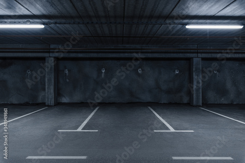 Sci fi looking dark and moody underground parking lot with fluorescent lights on. Concrete wall
