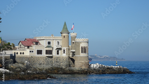 Historic castle in front of the sea with a Chilean flag flying on the tower