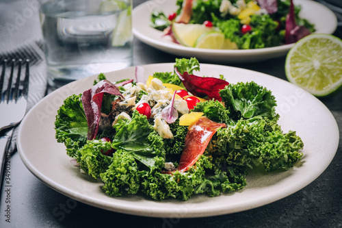 Tasty fresh kale salad on grey table, closeup. Food photography