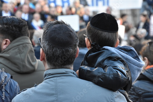 A man holding a child in his arms photographed from the back