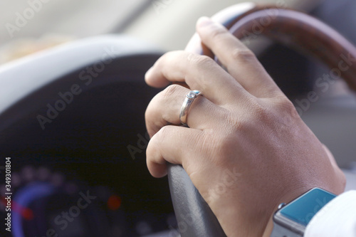 Hand holding car steering wheel, car driving