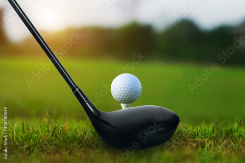 Golf clubs and golf balls on a green lawn in a beautiful golf course with morning sunshine