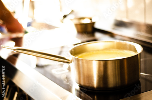 cooking vanilla cream in a saucepan on the electric stove