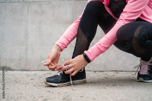 Athletic woman tying her shoelaces.