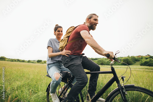 Romantic couple is riding a bike together in nature