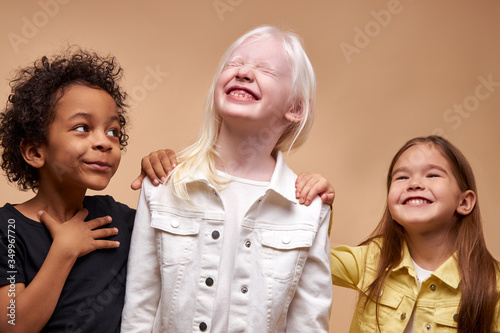 portrait of adorable diverse children isolated. black afro, albino and european children stand together, close friendship between them. people diversity, children, natural beauty concept