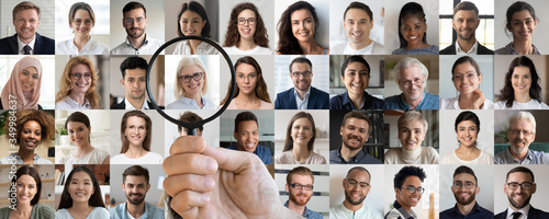 Employer hand holding magnifying glass choosing old middle aged female candidate among young multiethnic professional people faces collage. Human resource, headhunting, senior job opportunity concept.