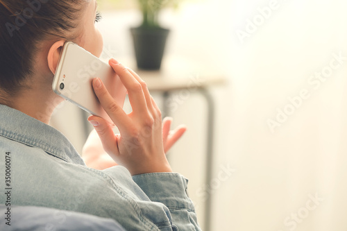 Woman talking by mobile phone at home