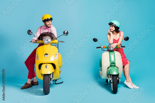 Portrait of his he her she nice attractive cheerful cheery couple sitting on moped wearing retro festal look communicating acquaintance isolated on bright vivid shine vibrant blue color background