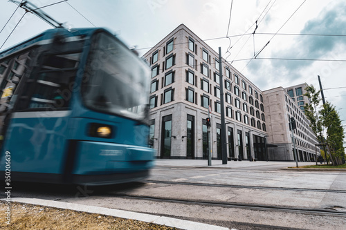 Zug kreuzt dynamisch vor modernem Bürogebäude in der Stadt