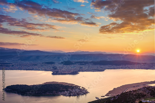 View of the small island of Kyra Frosini in lake Pamvotida with the ferry transporting tourists from Ioannina during sunset