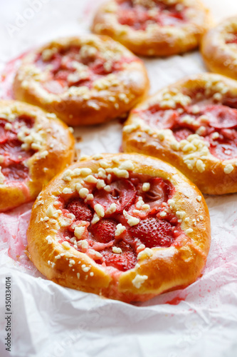 Yeast sweet rolls with the addition of strawberries and crumble, close up view. Traditional kolaches