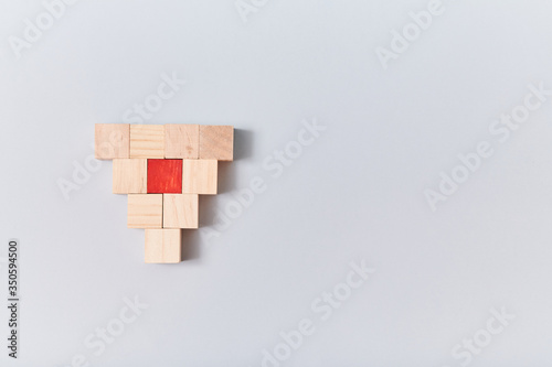 Empty wooden cube and one red, mockup style, place for text. Blank blocks in form of inverted pyramid. Isolated on blue