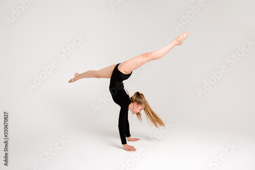 young beautiful girl gymnast on a white background. a young girl is engaged in gymnastics on a white background.
