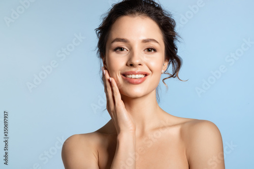 Young woman enjoy smooth skin and touching cheek with hand. 