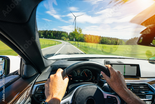 hands of car driver on steering wheel, road trip, driving on highway road