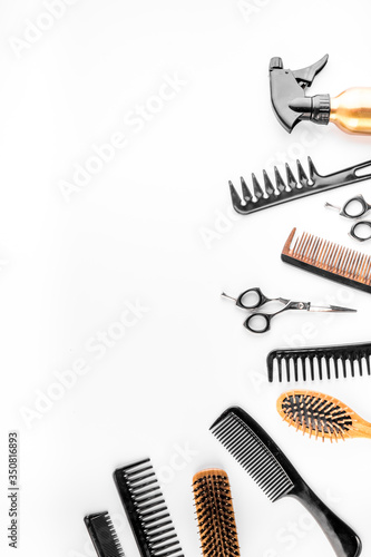 Hairdressing instruments. Combs, scissors and spray on white desk from above frame space for text